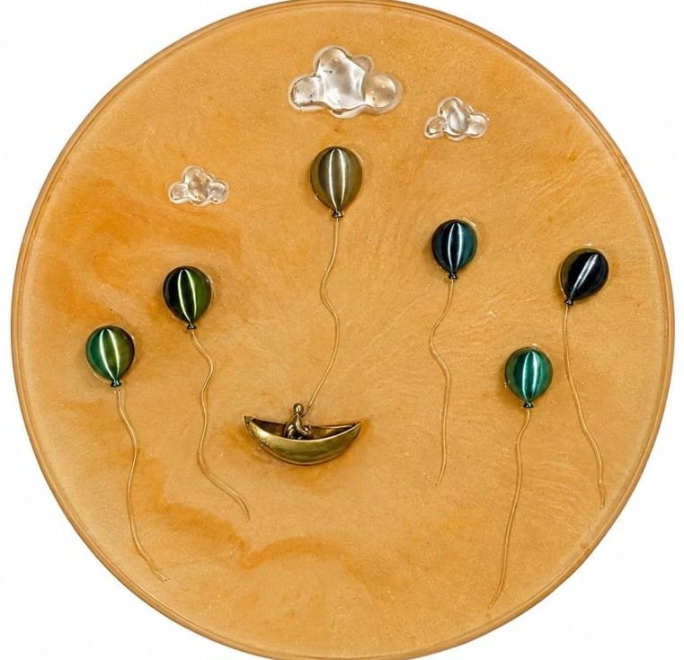 Round amber panel with green striped balloons, clouds and a gilded boat with a small figure