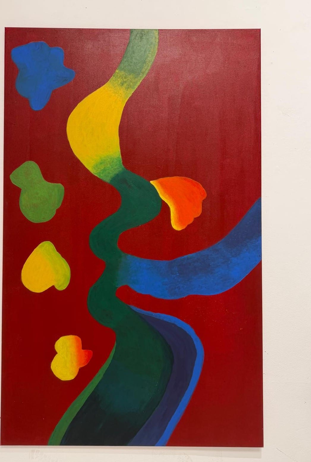 Vertical abstract painting of a winding green and blue path with floating color forms on red