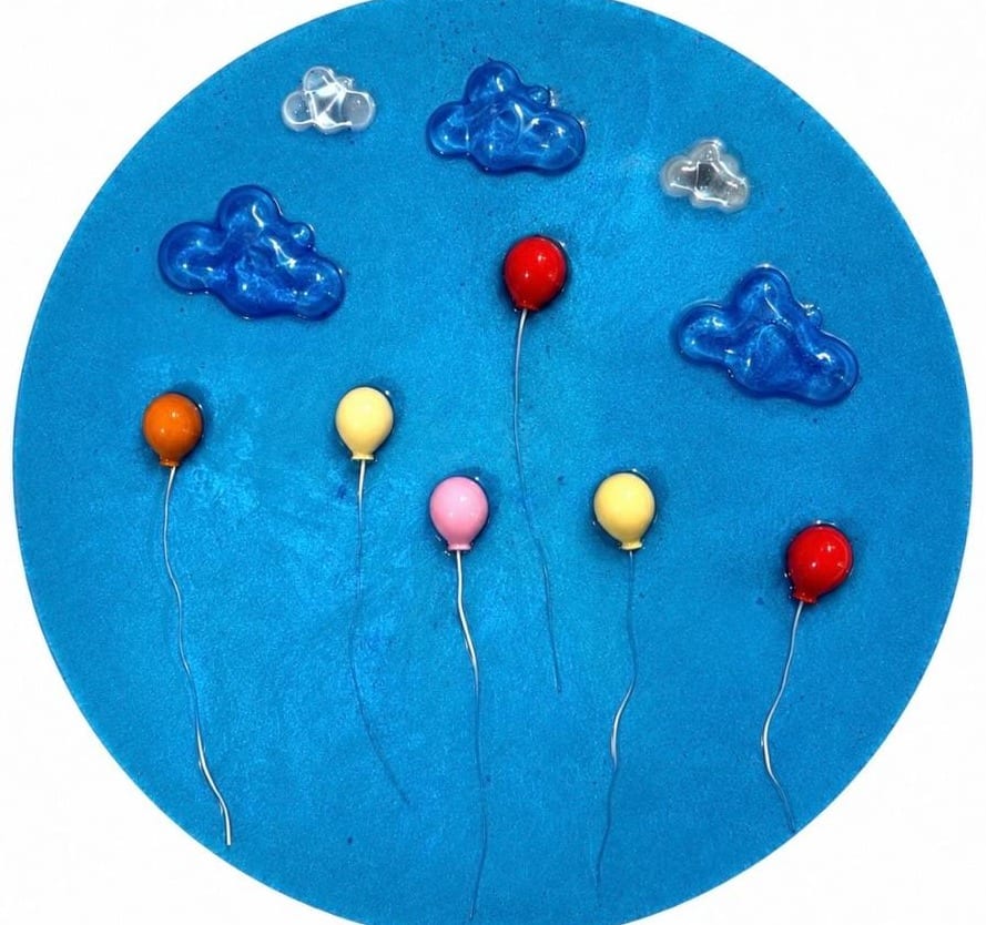 Round bright blue panel with blue glass clouds and red, orange, yellow and pink balloons